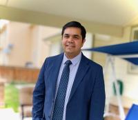 Rajesh smiling in a blue suit