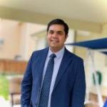 Rajesh smiling in a blue suit